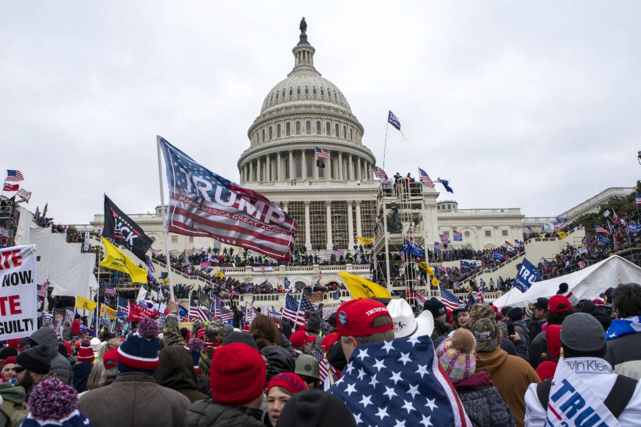 Protesters loyal to President Donald Trump storm the U.S. Capitol in Washington on Jan. 6, 2021, while others watch from below. The U.S. Supreme Court on Thursday heard arguments on whether Colorado can remove Trump from its primary ballot for violating the Constitution’s insurrection provision. (Jose Luis Magana / Associated Press file photo)