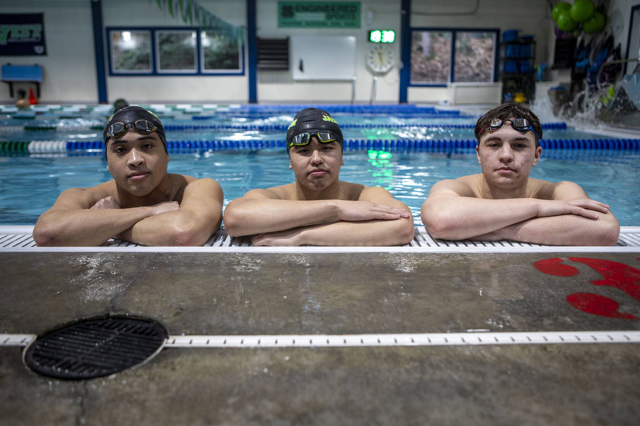 Left to right, Jackson High School swimmers Ethan Chen-Parks, Vyron Domingo, and Ethan Georgiev pose for a photo on Wednesday, Feb. 7, 2024 at West Coast Aquatics in Bothell, Washington. (Annie Barker / The Herald)