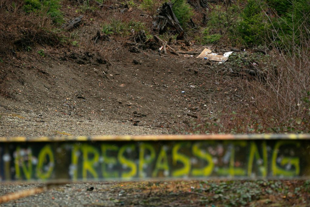 Old targets and clay pigeons are seen beyond a “NO SHOOTING, NO TRESPASSING” sign along Sultan Basin Road on Thursday, Feb. 8, 2024, in Sultan, Washington. (Ryan Berry / The Herald)
