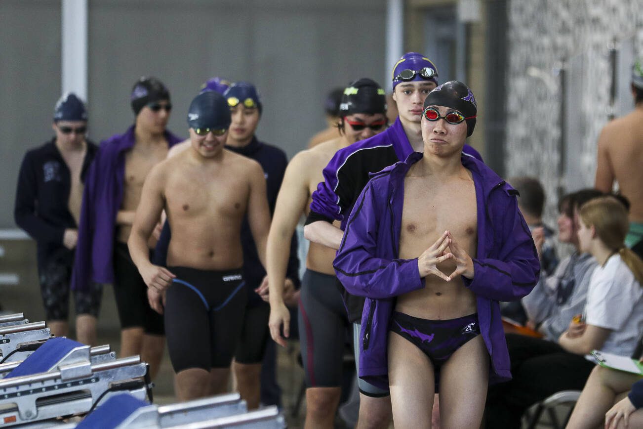 Swimmers walk out for Heat 1 of the 200 Yard IM during the 4A District 1 swim and dive championships at Snohomish Aquatic Center, in Snohomish, Washington on Saturday, Feb. 11, 2023.  (Annie Barker / The Herald)