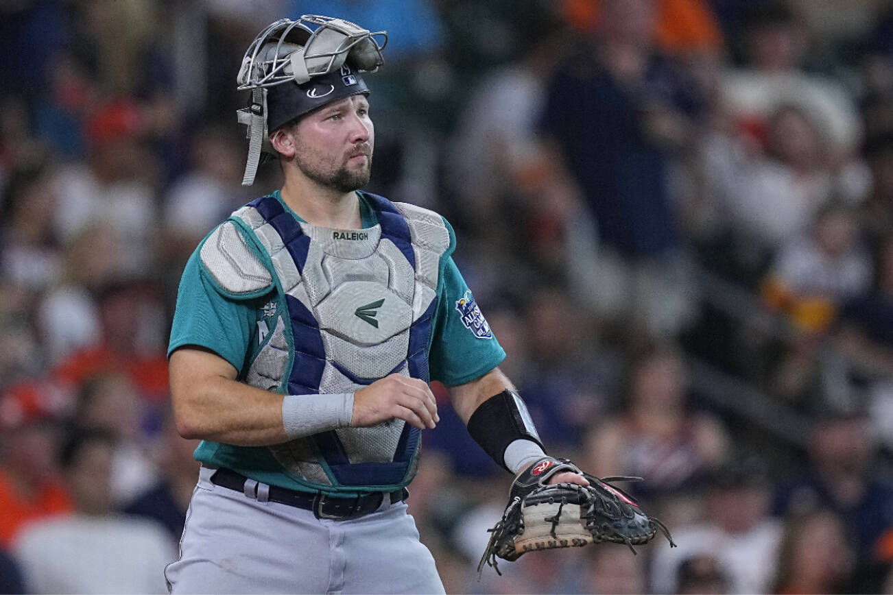 Seattle Mariners catcher Cal Raleigh signals during the second inning of a baseball game against the Houston Astros, Saturday, Aug. 19, 2023, in Houston. (AP Photo/Kevin M. Cox)
