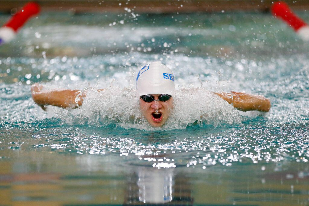 Shorewood’s Larson Buchholz swims in the 100 yard butterfly during the Class 3A District 1 swim and dive meet Saturday at the Snohomish Aquatic Center in Snohomish. (Ryan Berry / The Herald)
