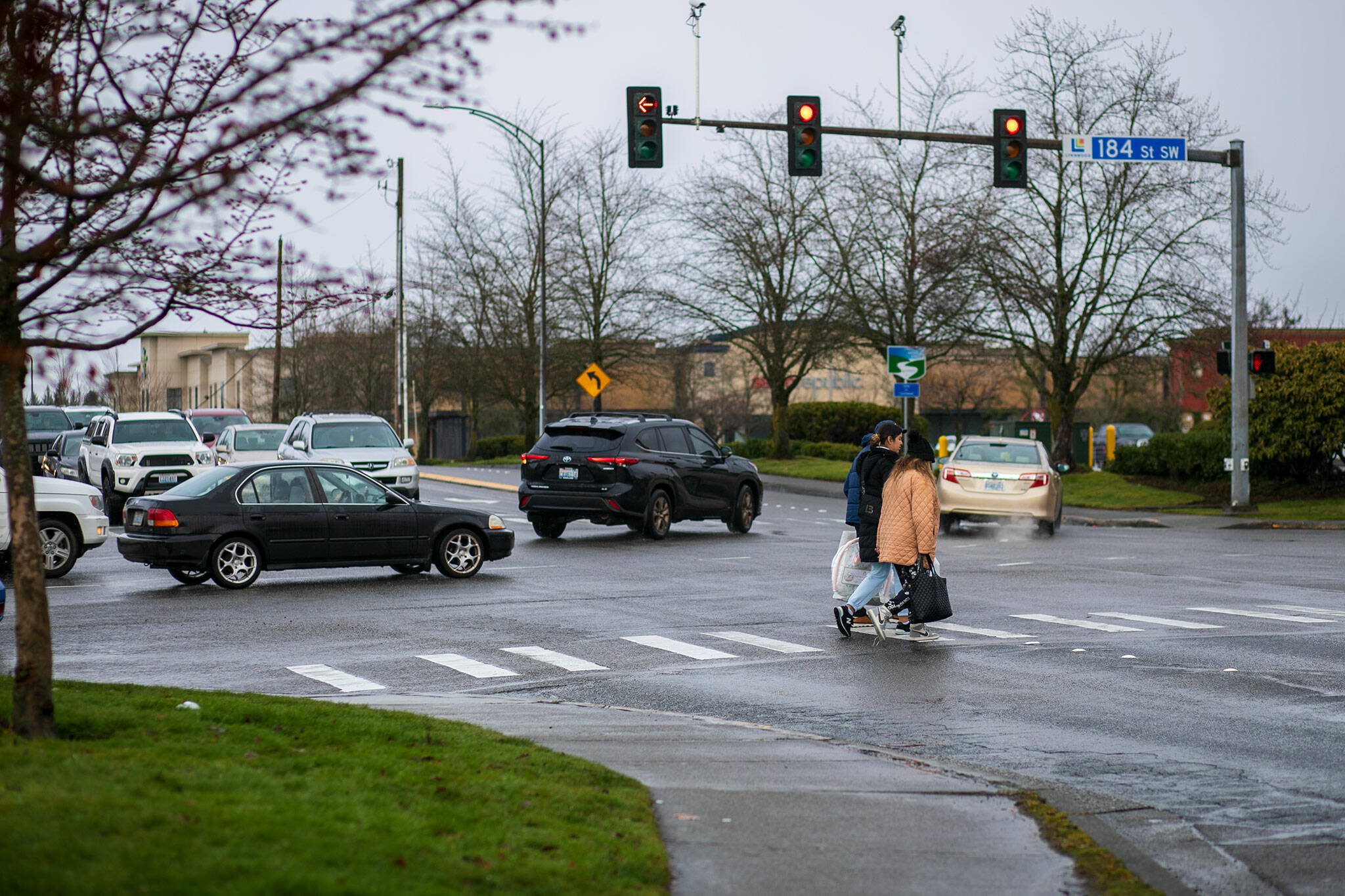 Shoppers cross Alderwood Mall Parkway after leaving the mall and walking through its parking lot on Thursday, Feb. 15, 2024, in Lynnwood, Washington. (Ryan Berry / The Herald)
