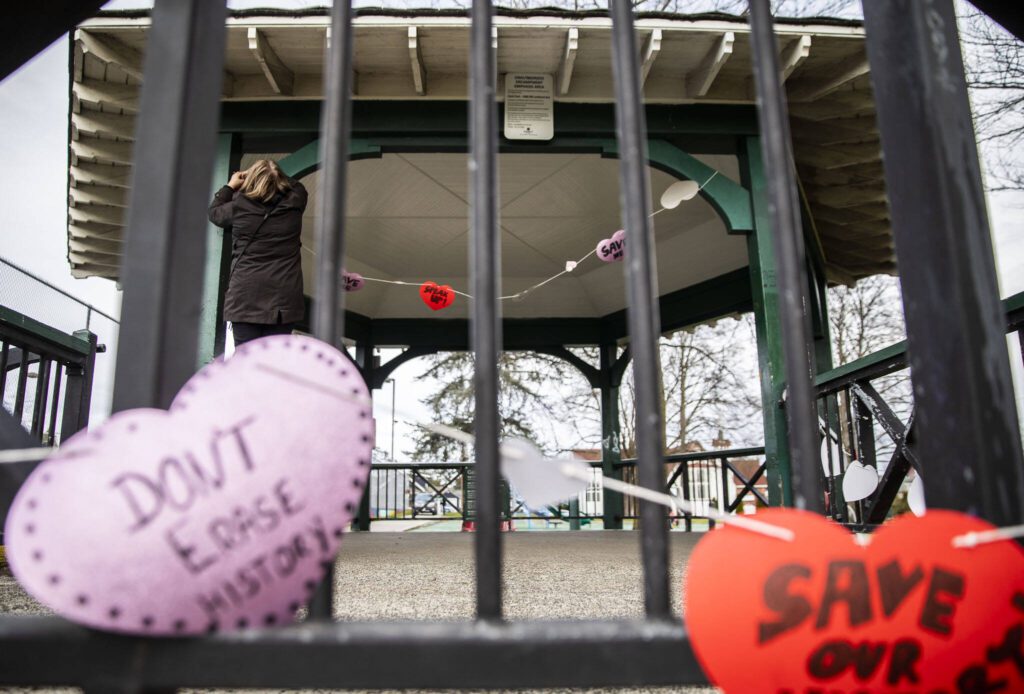 People hang up hearts with messages about saving the Clark Park gazebo during a “heart bomb” event hosted by Historic Everett on Saturday, Feb. 17, 2024 in Everett, Washington. (Olivia Vanni / The Herald)
