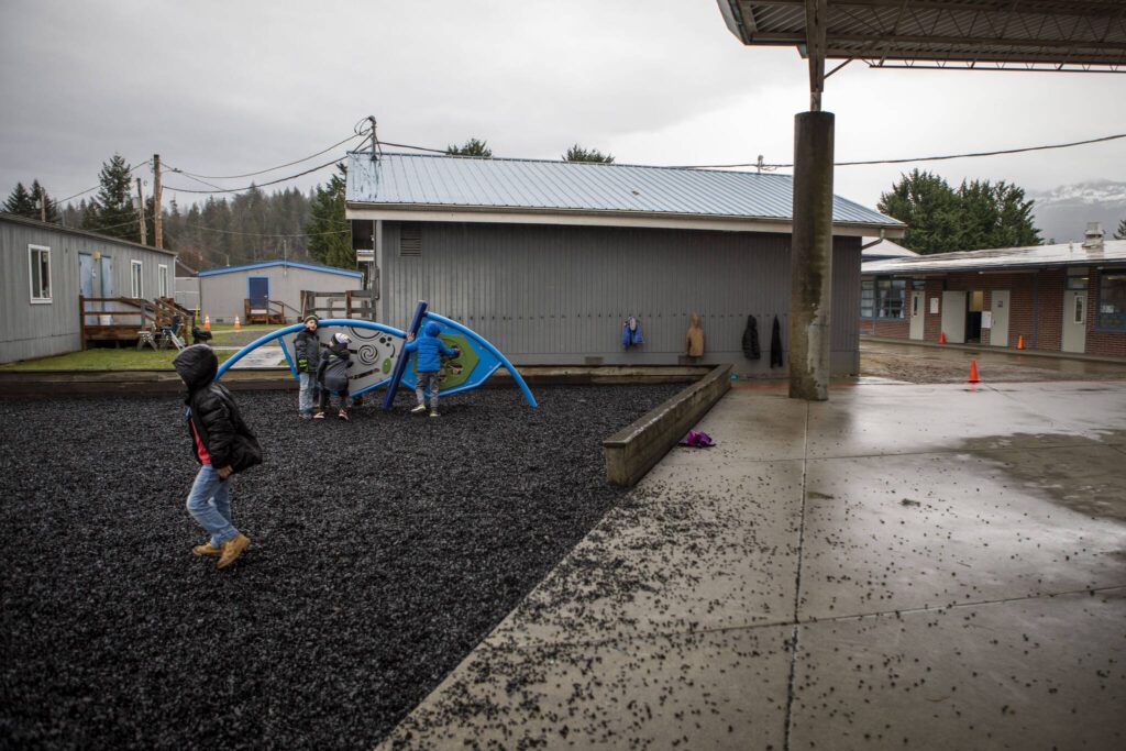 Children play next to the main school building and portable classrooms at the Sultan Elementary School on Wednesday, Jan. 24, 2024 in Sultan, Washington. (Annie Barker / The Herald)
