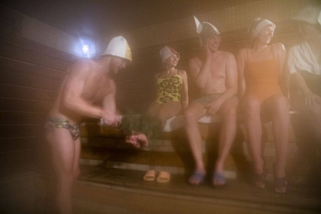 A group of friends hang out in the sauna at Banya, an Eastern European style spa in downtown Everett with a sauna that is hotter than a traditional sauna. The gentle swatting by branches intensifies the body heat to better withstand a plunge into a cold pool. (Olivia Vanni / The Herald)
