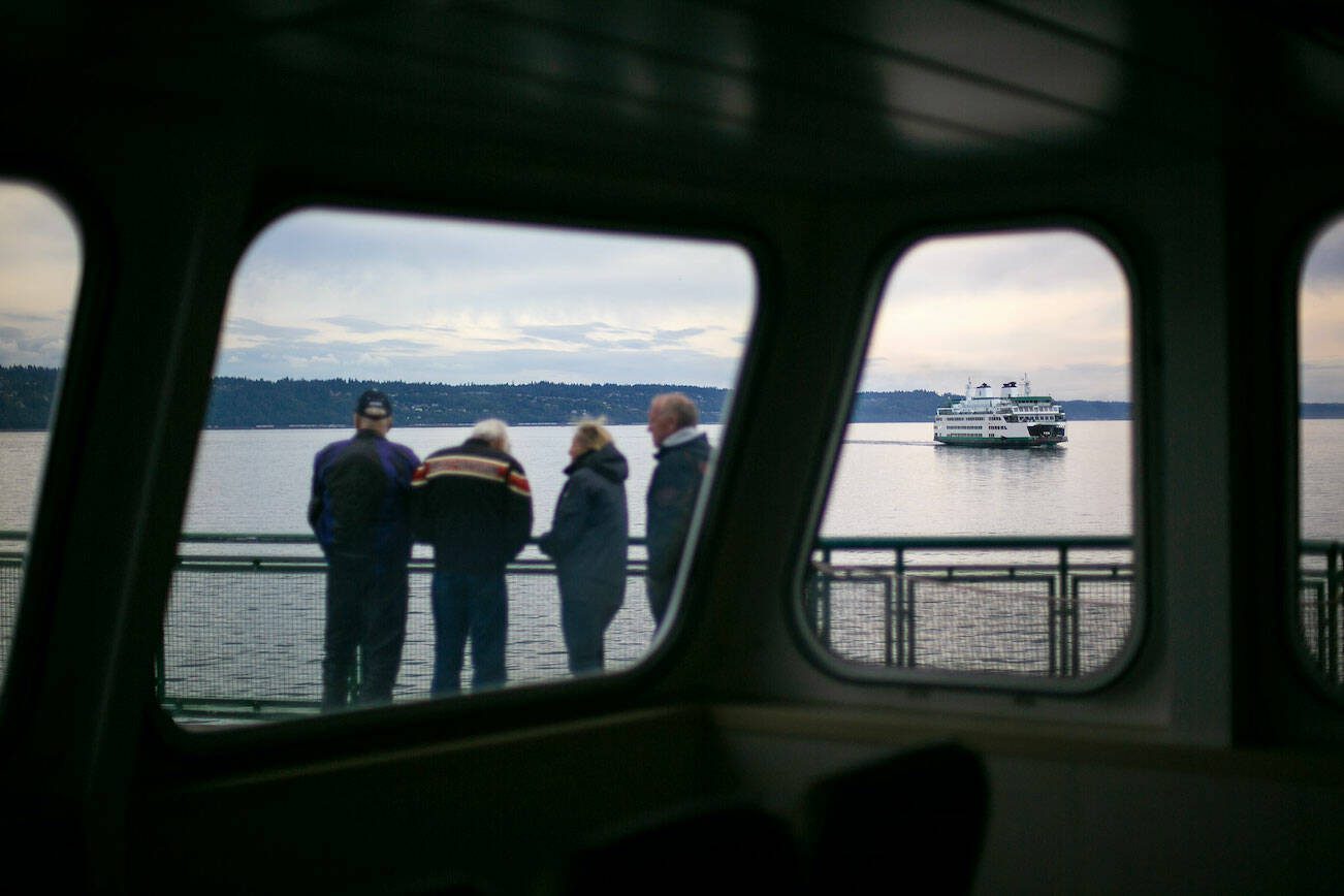 A group of travelers aboard the MV Suquamish watch from the sun deck as MV Tokitae passes starboard side on Thursday, Sept. 7, 2023, in the waters near Clinton, Washington. (Ryan Berry / The Herald)