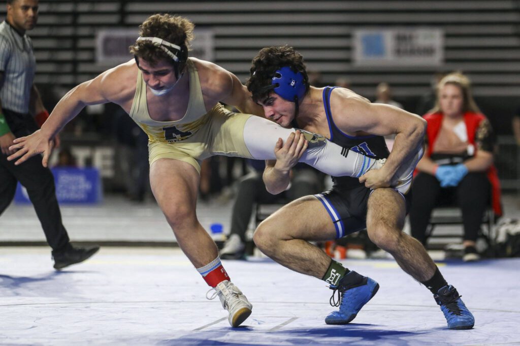 Arlington’s Dustin Baxter and Walla Walla’s Mateo Caso wrestle during the 3A Boys 152-pound championship match during Mat Classic XXXIV on Feb. 18, 2023, at the Tacoma Dome in Tacoma. (Annie Barker / The Herald)
