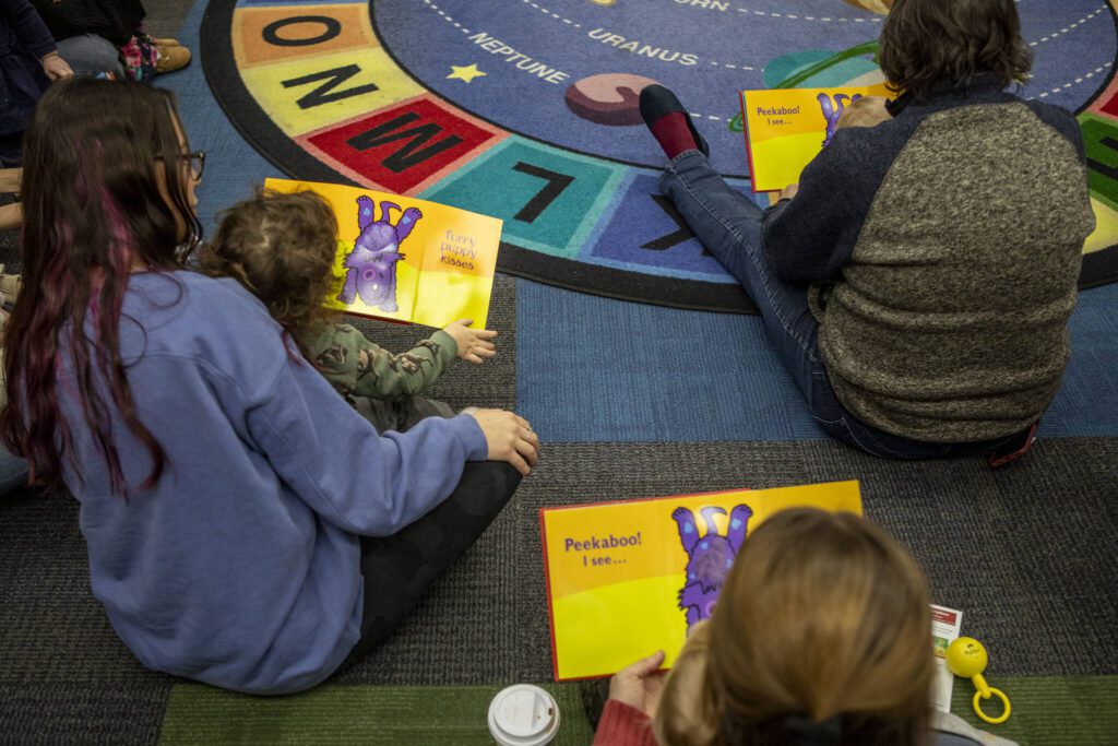 Adults and kids read during Toddler Storytime at the Main Everett Library on Tuesday, Feb. 13, 2024 in Everett, Washington. (Annie Barker / The Herald)

