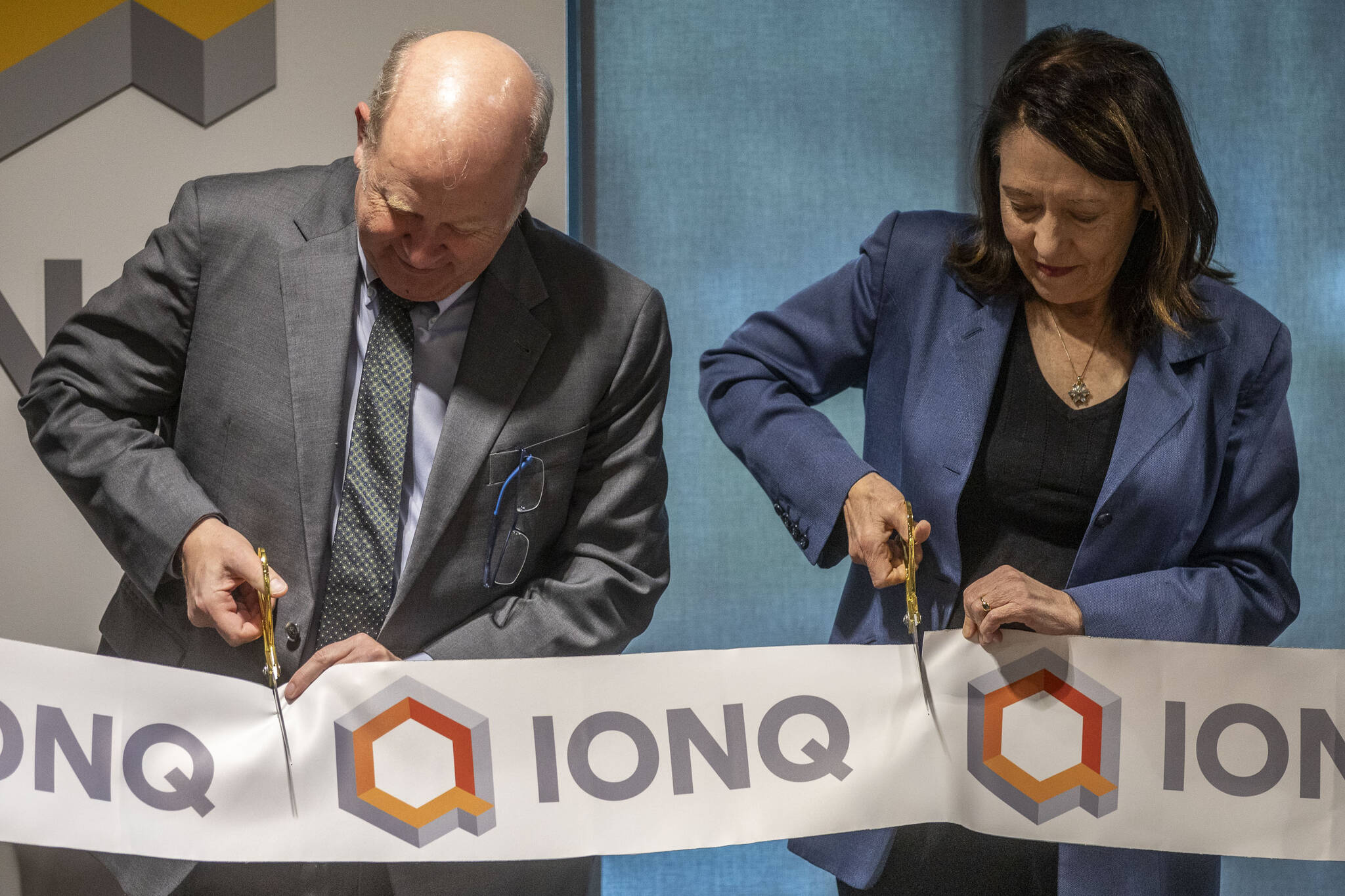 IonQ CEO Peter Chapman, left, and Sen. Maria Cantwell, right, cut a ribbon during an IonQ event at their research and manufacturing facility on Thursday, Feb. 15, 2024 in Bothell, Washington. (Annie Barker / The Herald)