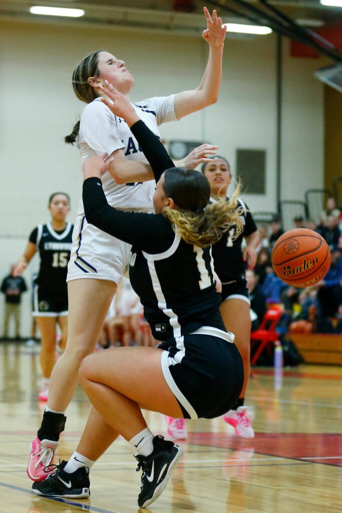 Arlington’s Addi Green collides with Lynnwood’s Nyree Johnson during the 3A District One Semifinals on Wednesday, Feb. 14, 2024, at Marysville Pilchuck High School in Marysville, Washington. (Ryan Berry / The Herald)
