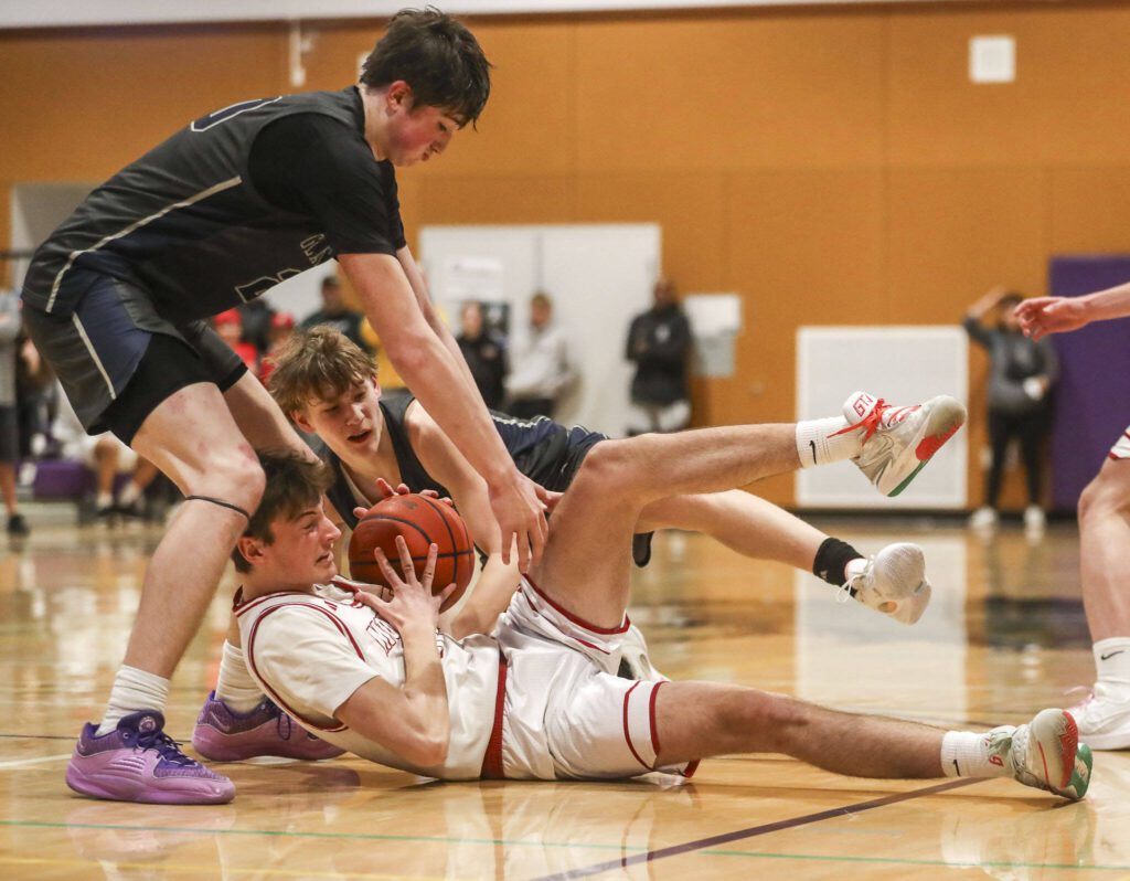 Players fight for the ball during a boys Class 4A bi-district title game between Glacier Peak and Mount Si at North Creek High School on Friday, Feb. 16, 2024 in Bothell, Washington. The Wildcats won, 59-53.(Annie Barker / The Herald)
