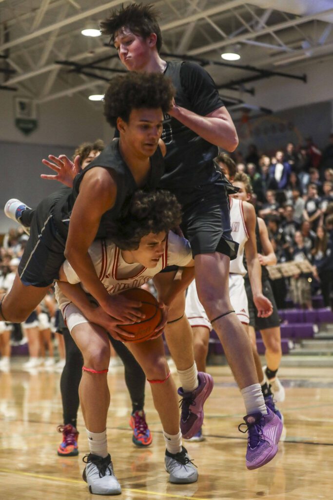 Players fight for the ball during a boys Class 4A bi-district title game between Glacier Peak and Mount Si at North Creek High School on Friday, Feb. 16, 2024 in Bothell, Washington. The Wildcats won, 59-53.(Annie Barker / The Herald)
