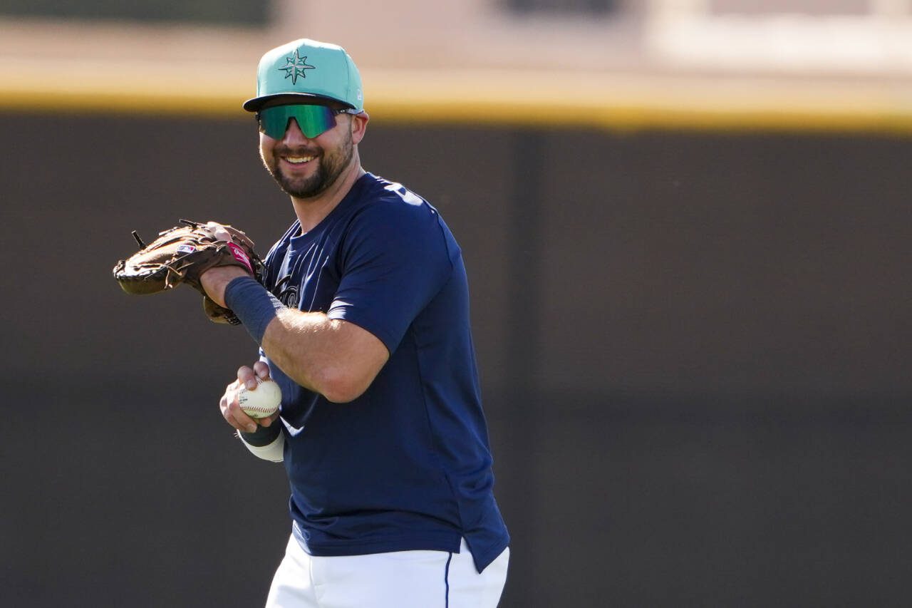 Seattle Mariners catcher Cal Raleigh smiles while warming up during spring training workouts Thursda in Peoria, Ariz. (AP Photo/Lindsey Wasson)