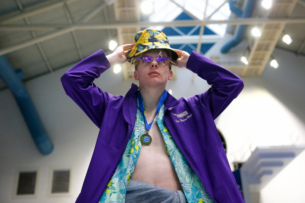 Lake Stevens junior Camden Blevins-Mohr dons his bucket hat after receiving one of his two state champion medals during the WIAA 4A Boys Swim and Dive Championships on Saturday, Feb. 17, 2024, at the Weyerhaeuser King County Aquatic Center in Federal Way, Washington. (Ryan Berry / The Herald)
