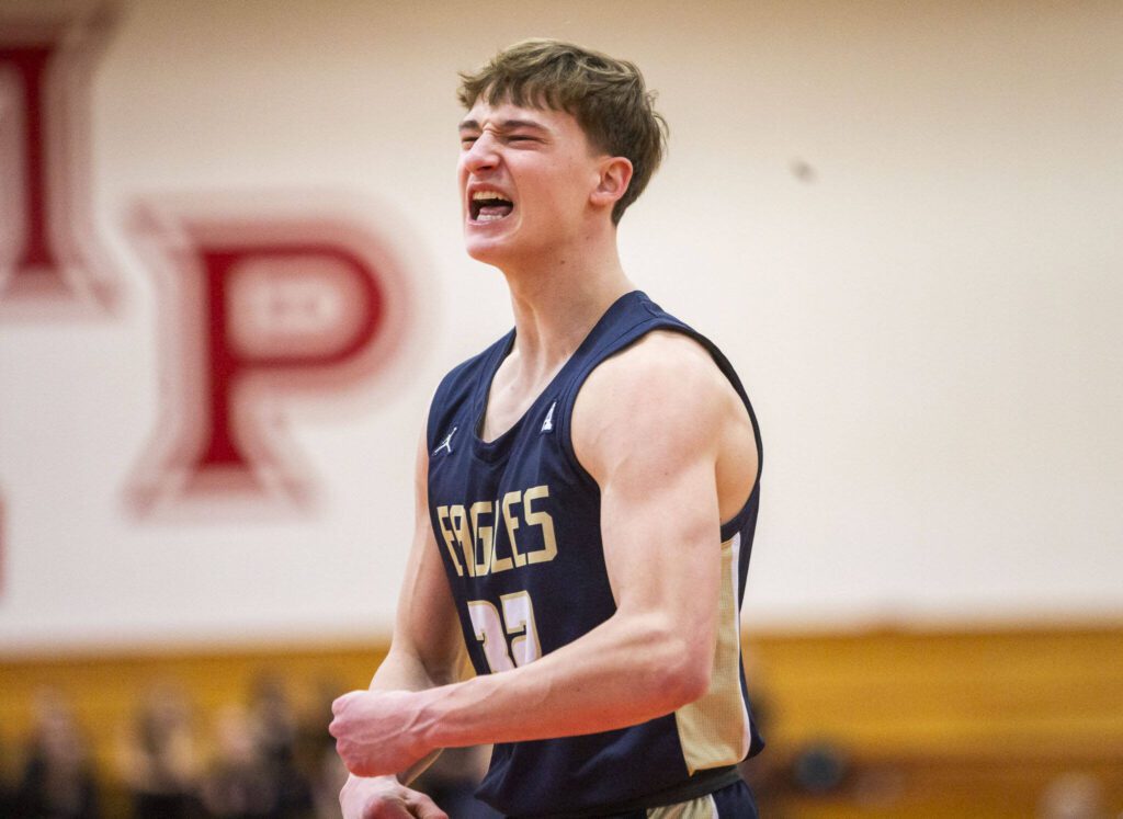 Arlington’s Kaid Hunter cheers after a teammate hits a three point shot during the 3A boys district championship game against Mountlake Terrace on Saturday, Feb. 17, 2024 in Marysville, Washington. (Olivia Vanni / The Herald)
