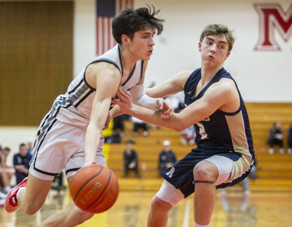 Mountlake Terrace’s Jaxon Dubiel tries to maneuver around Arlington’s Leyton Martin during the 3A boys district championship game on Saturday, Feb. 17, 2024 in Marysville, Washington. (Olivia Vanni / The Herald)
