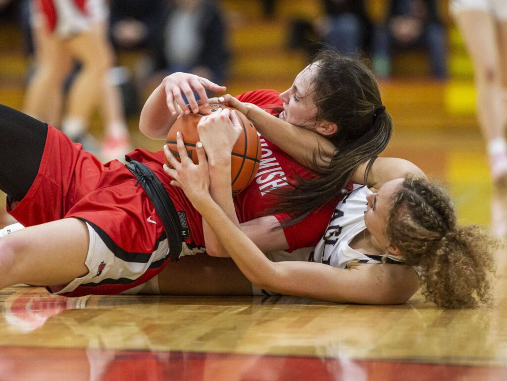 Snohomish’s Sienna Capelli and Arlington’s Samara Morrow scramble for the ball during the 3A girls district championship game on Saturday, Feb. 17, 2024 in Marysville, Washington. (Olivia Vanni / The Herald)
