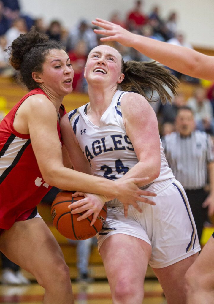 Snohomish’s Tyler Gildersleeve-Stiles fouls Arlington’s Katie Snow while she tries to shoot during the 3A girls district championship game on Saturday, Feb. 17, 2024 in Marysville, Washington. (Olivia Vanni / The Herald)

