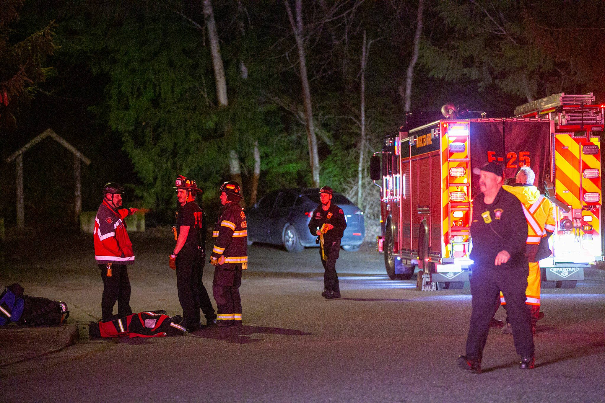 Emergency responders stage outside the Japanese Gulch 19th Street Trailhead while searching for an airplane that crashed in the area on Friday, Feb. 16, 2024, in Everett, Washington. (Ryan Berry / The Herald)