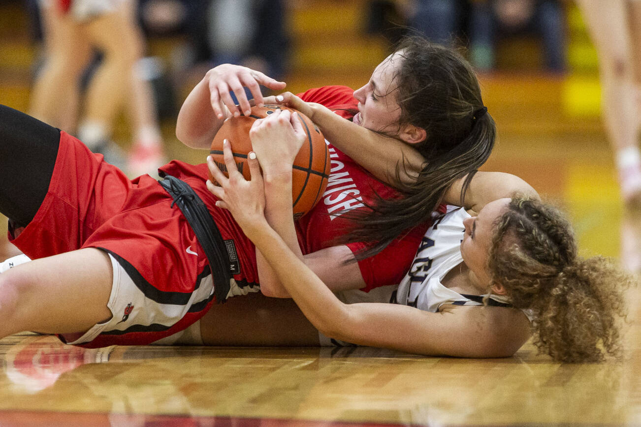 Snohomish’s Sienna Capelli and Arlington’s Samara Morrow scramble for the ball during the 3A girls district championship game on Saturday, Feb. 17, 2024 in Marysville, Washington. (Olivia Vanni / The Herald)