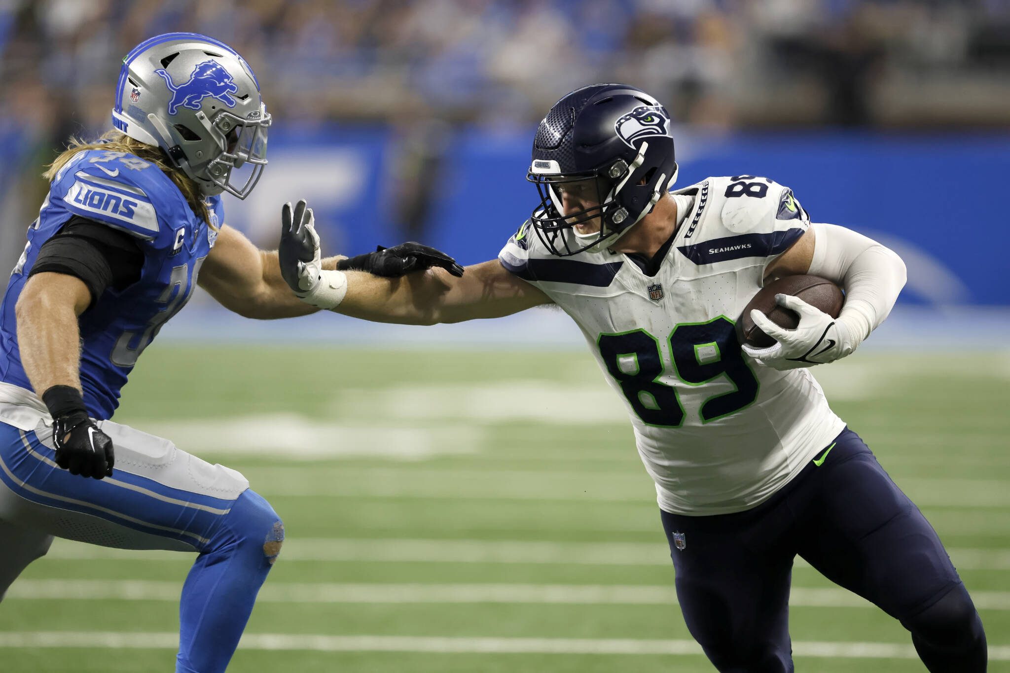 Seattle Seahawks tight end Will Dissly (89) stiff arms Detroit Lions linebacker Alex Anzalone (34) while carrying the ball against the Detroit Lions on Sept. 17, 2023, in Detroit. (AP Photo/Duane Burleson)
