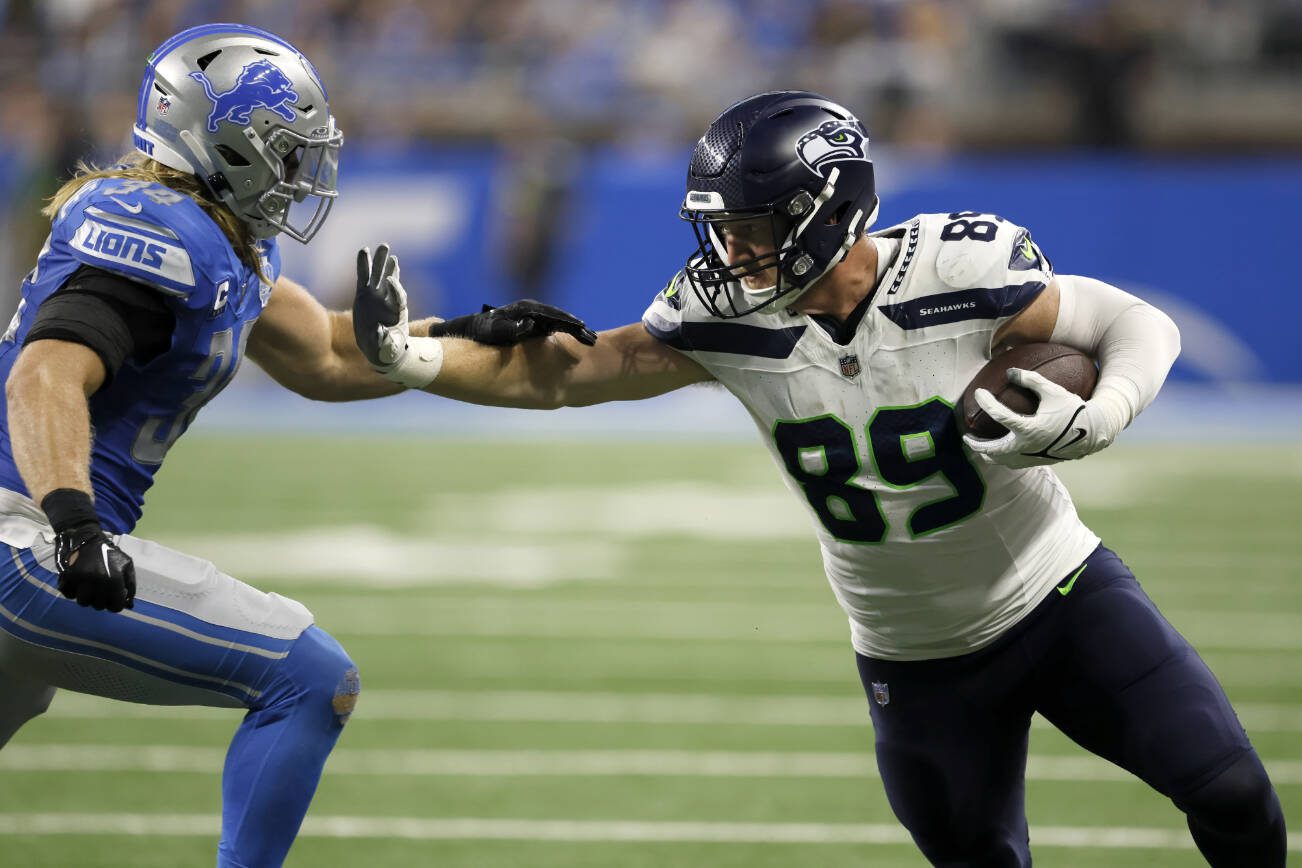 Seattle Seahawks tight end Will Dissly (89) stiff arms Detroit Lions linebacker Alex Anzalone (34) while carrying the ball against the Detroit Lions during the second half of an NFL football game Sunday, Sept. 17, 2023, in Detroit. (AP Photo/Duane Burleson)