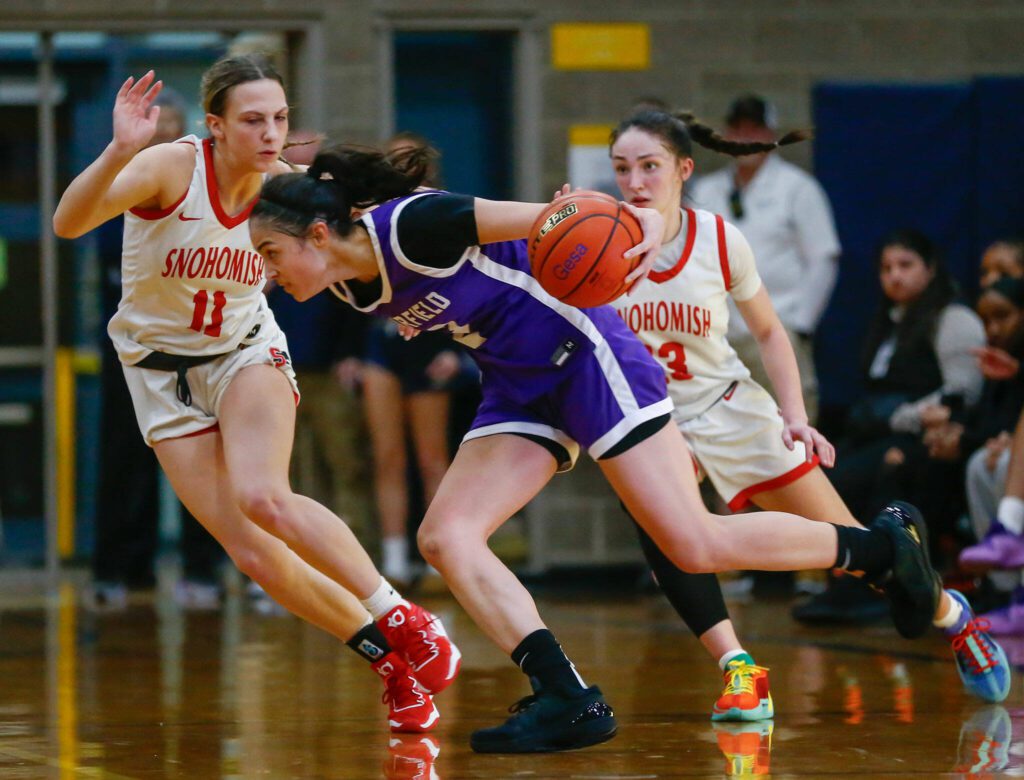 The Snohomish defense doubles up on Garfield’s Katie Fiso during a playoff matchup at Arlington High School on Friday, Feb. 23, 2024, in Arlington, Washington. (Ryan Berry / The Herald)
