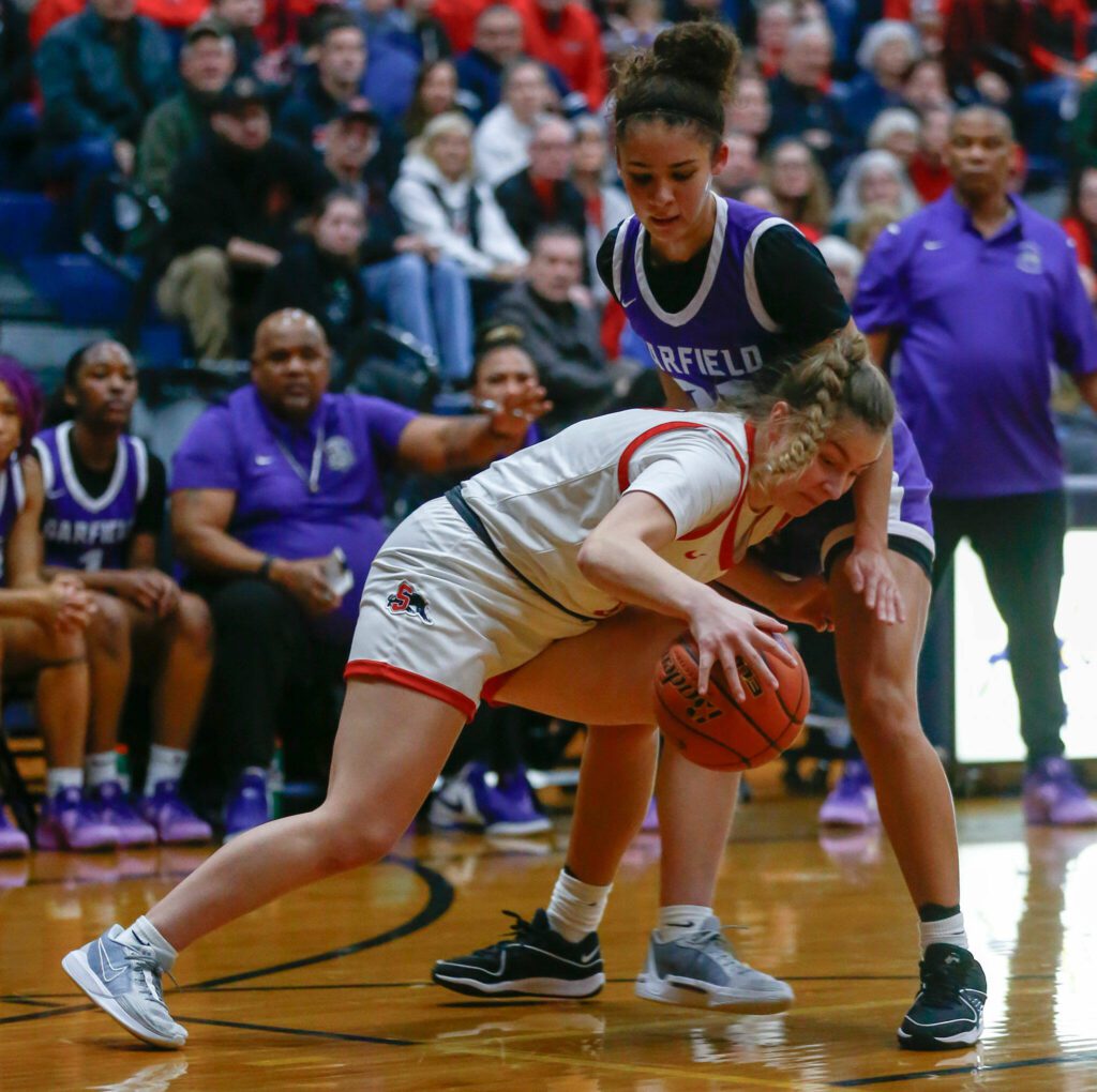 Snohomish sophomore Kendall Hammer tries to dribble through a defender against Garfield during a playoff matchup at Arlington High School on Friday, Feb. 23, 2024, in Arlington, Washington. (Ryan Berry / The Herald)
