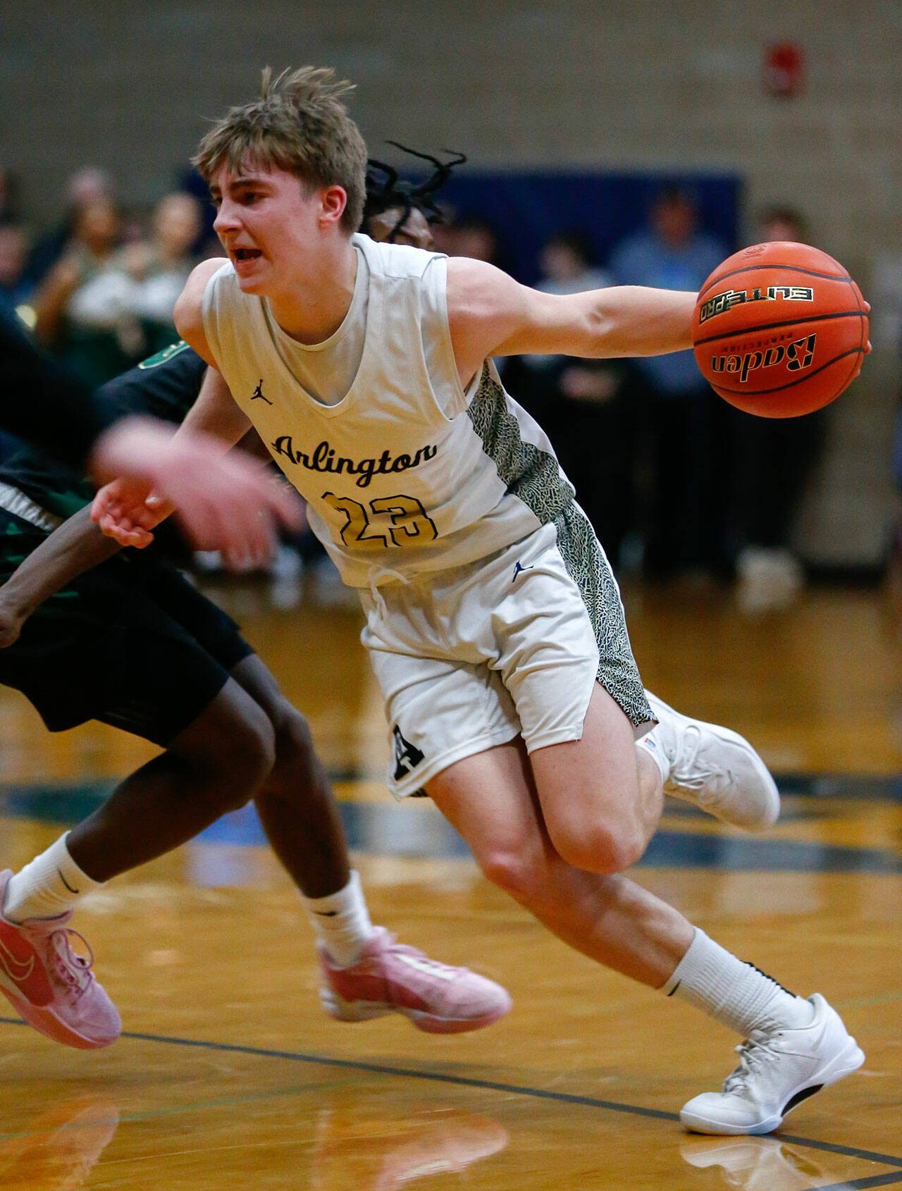 Arlington junior guard Leyton Martin drives on a defender against Marysville Getchell during a playoff matchup at Arlington High School on Saturday, Feb. 24, 2024, in Arlington, Washington. (Ryan Berry / The Herald)