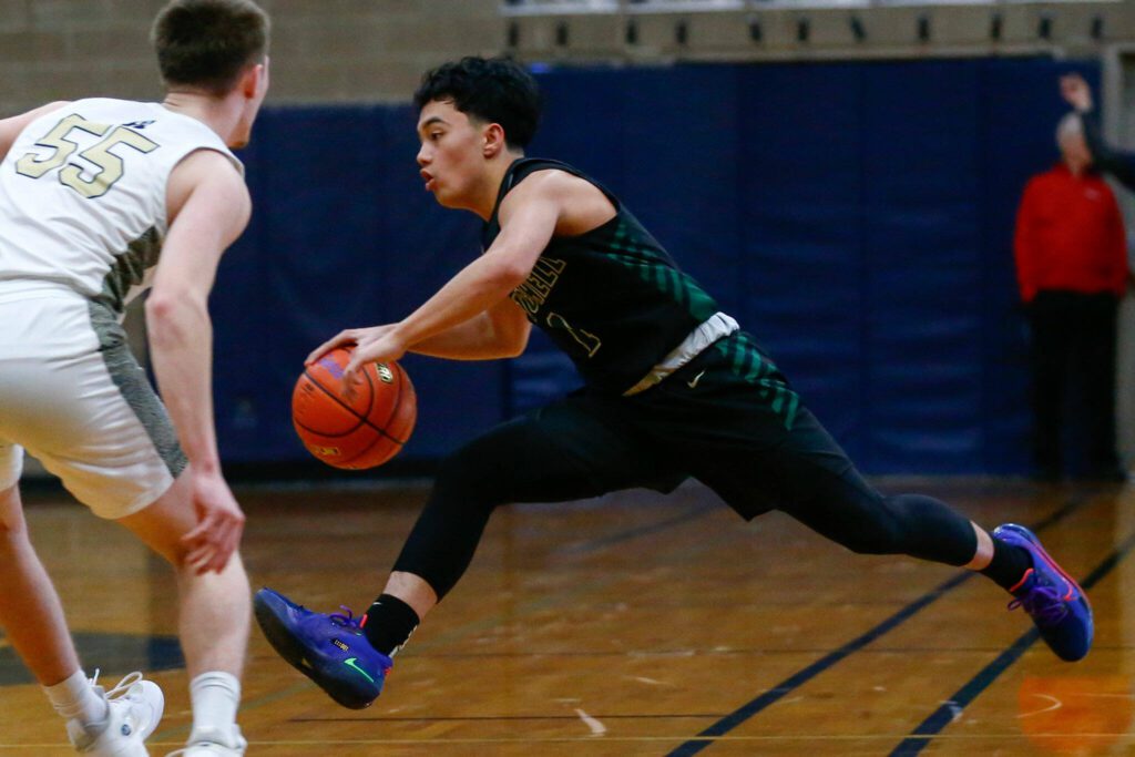 Marysville Getchell junior Bubba Palocol reverses directions while dribbling against Arlington during a playoff matchup at Arlington High School on Saturday, Feb. 24, 2024, in Arlington, Washington. (Ryan Berry / The Herald)
