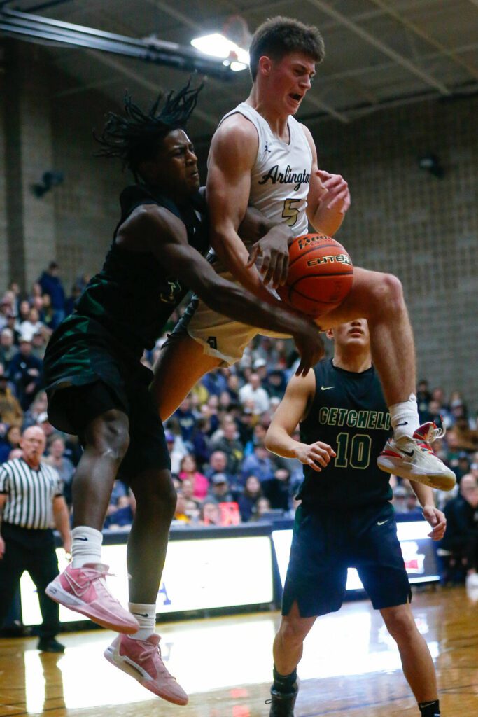 Arlington senior Jacoby Falor comes down with a rebound against Marysville Getchell during a playoff matchup at Arlington High School on Saturday, Feb. 24, 2024, in Arlington, Washington. (Ryan Berry / The Herald)
