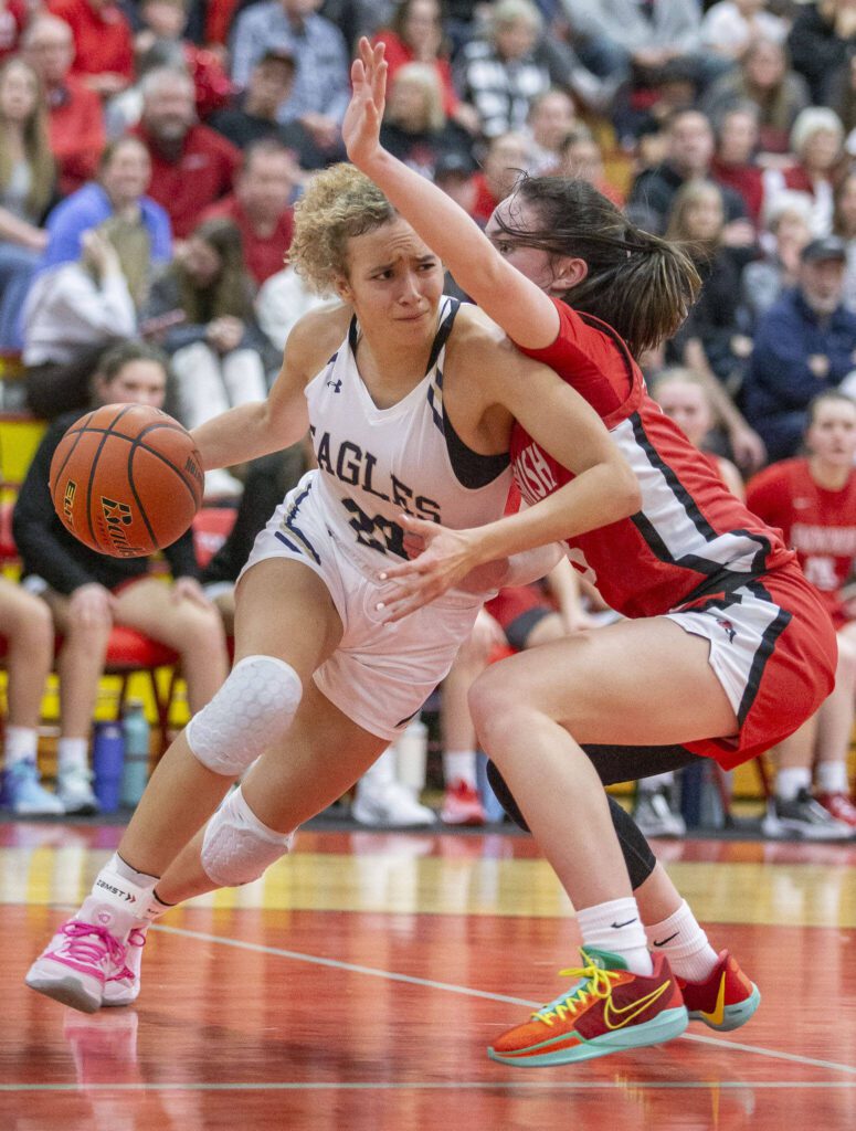 Arlington’s Samara Morrow tries to maneuver around Snohomish’s Sienna Capelli during the 3A girls district championship game Feb. 17 in Marysville. (Olivia Vanni / The Herald)
