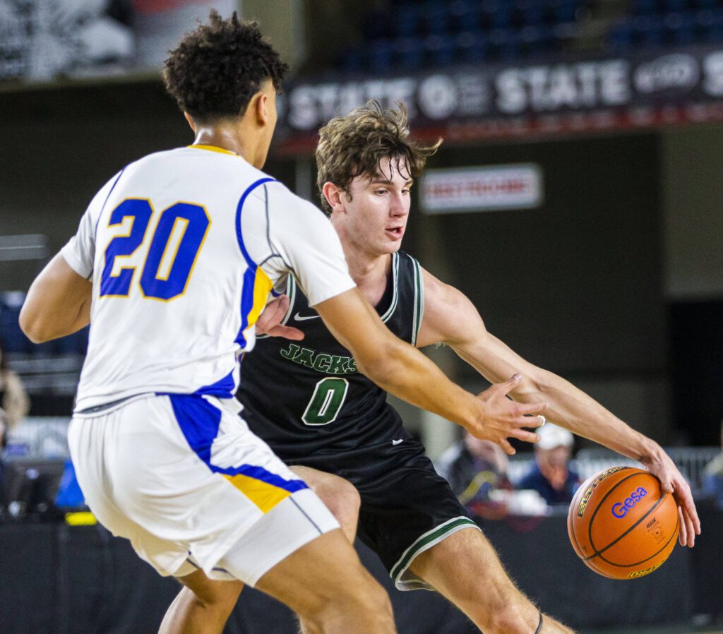 Jackson’s Ryan Mcferran maneuvers around Tahoma’s Jayden Stephens during the 4A boys state basketball game against Tahoma on Wednesday, Feb. 28, 2024 in Tacoma, Washington. (Olivia Vanni / The Herald)

