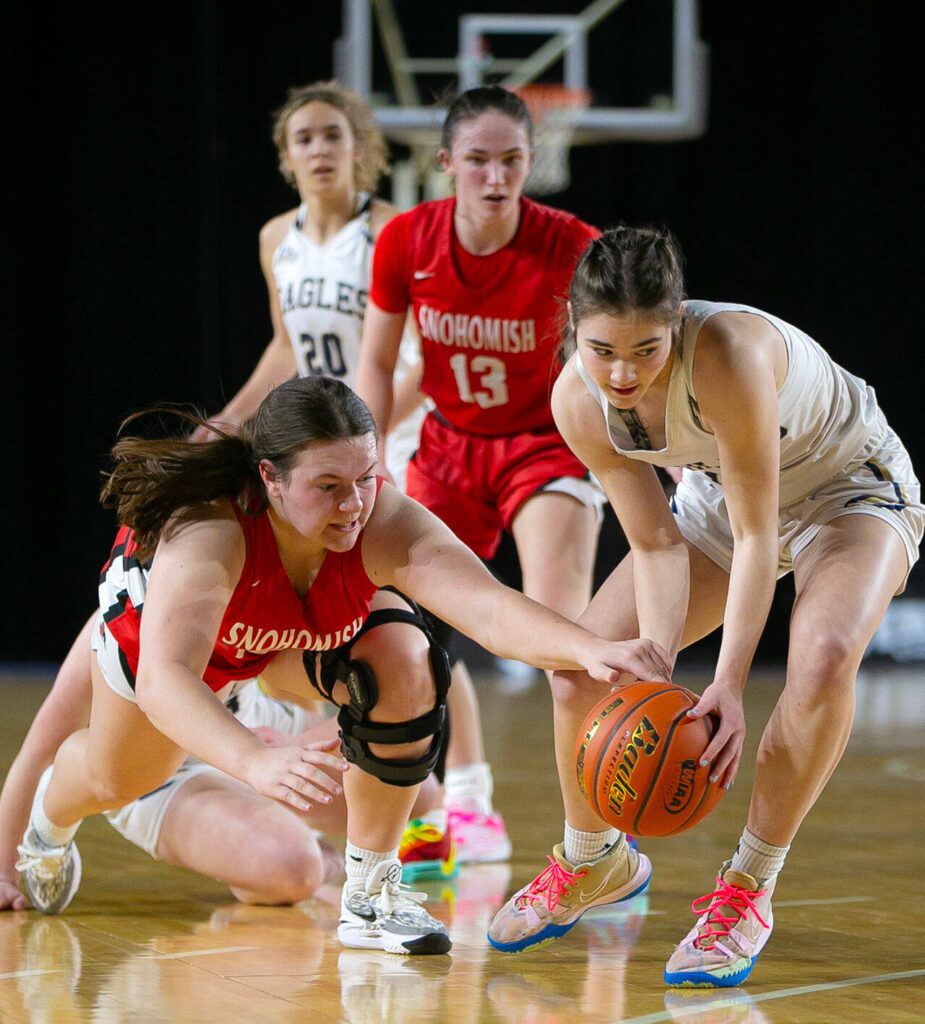 Arlington’s Khari Deberry swipes a loose ball from Snohomish’s Addyson Gallatin during a WIAA 3A Girls Basketball quarterfinal on Thursday, Feb. 29, 2024, at the Tacoma Dome in Tacoma, Washington. (Ryan Berry / The Herald)
