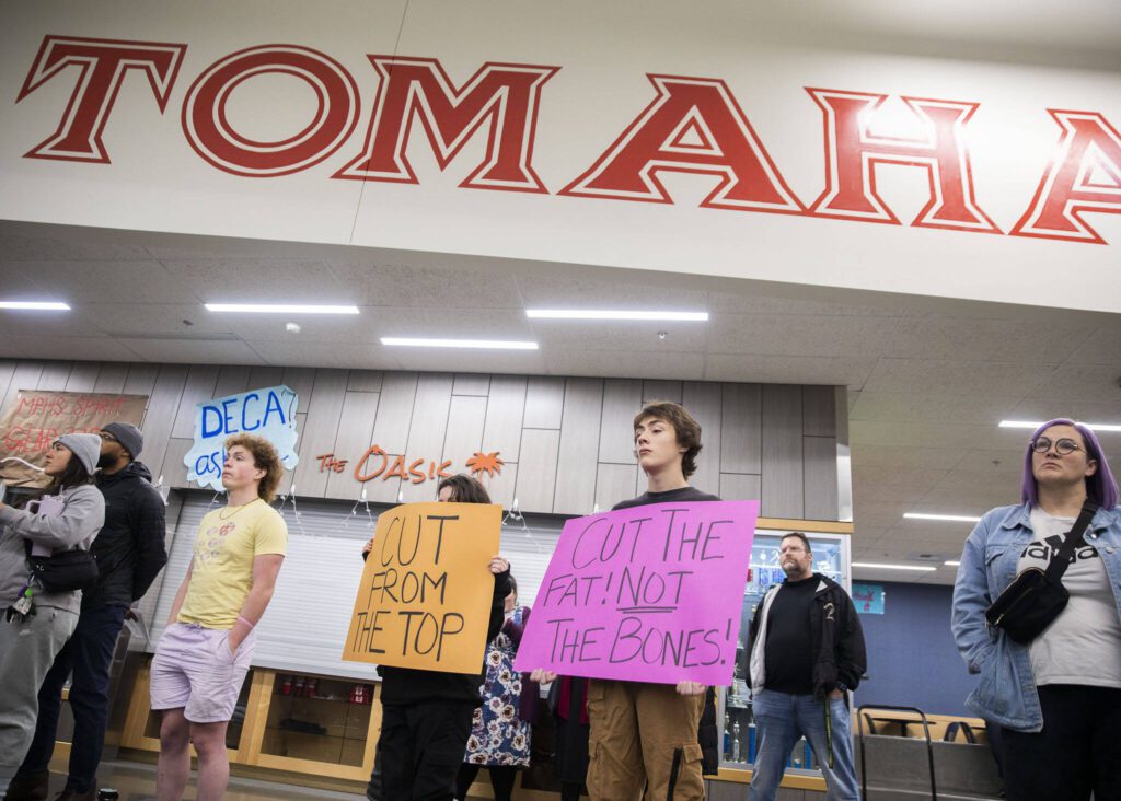 Pierce Butcher, 15, right, a sophomore at Marysville Getchell, holds a sign in silent protest at the Marysville School District budget presentation on Tuesday, Nov. 28, 2023 in Marysville, Washington. (Olivia Vanni / The Herald)
