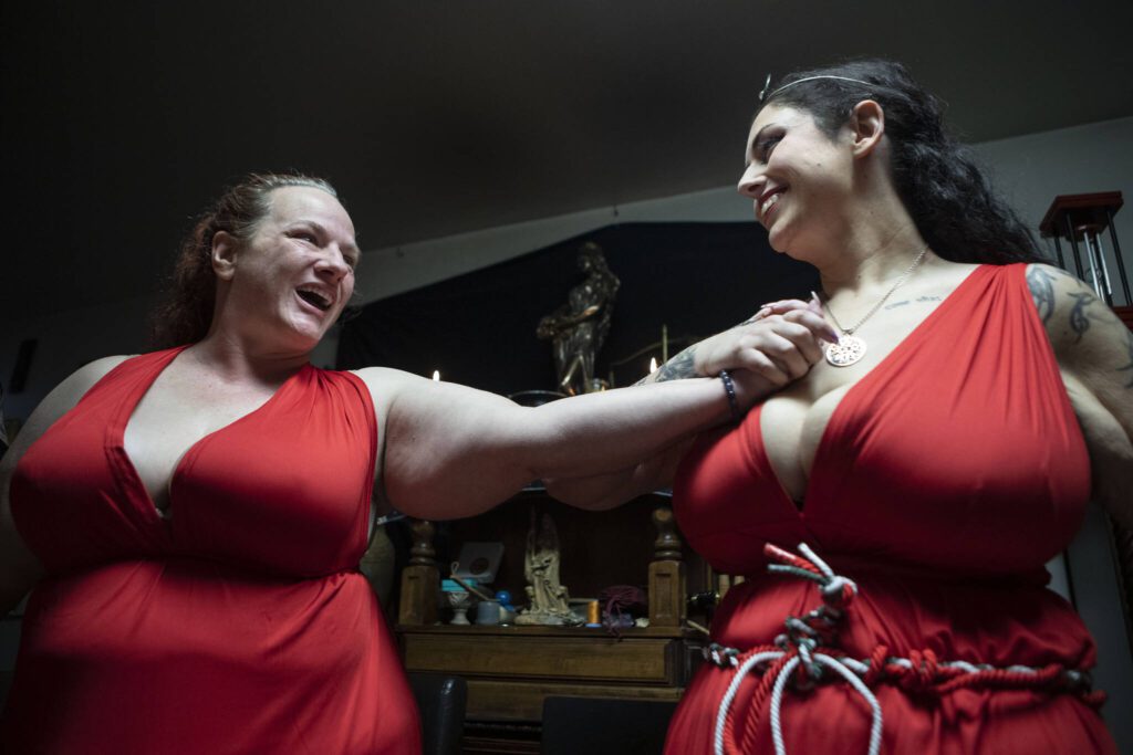 Isadora LaVeau, left, and N‘Mier LaVeau, right, cast a Circle at the start of Beltane in May 2023, at the Aquarian Tabernacle Church in Index, Washington. Beltane celebrates the height of spring. According to the church: “A Circle cast is to create a sacred space between the worlds, neither on this plane or the other, and to protect the space from outside, unwanted energy.” (Annie Barker / The Herald)
