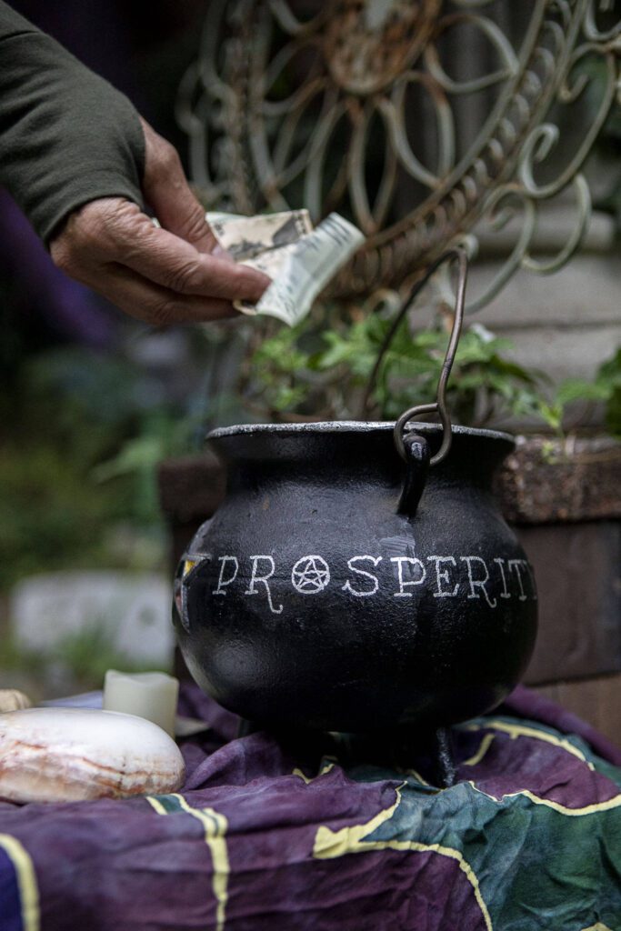 A Pagan donates to a cauldron labeled Prosperity” at the Aquarian Tabernacle Church in Index, Washington, in August 2023. (Annie Barker / The Herald)
