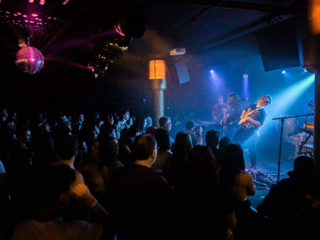 Jared Squires of Cytrus leans back while playing guitar during a headlining show at Madame Lou’s on Friday, Dec. 29, 2023 in Seattle, Washington. (Olivia Vanni / The Herald)
