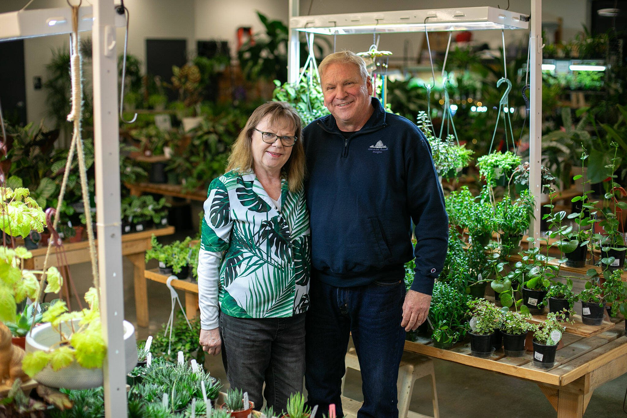 Houseplants Galore owners Carrie and Steve Compton stand amongst the foliage at their Everett Mall Way storefront on Friday, Jan. 12, 2024, in Everett, Washington. (Ryan Berry / The Herald)
