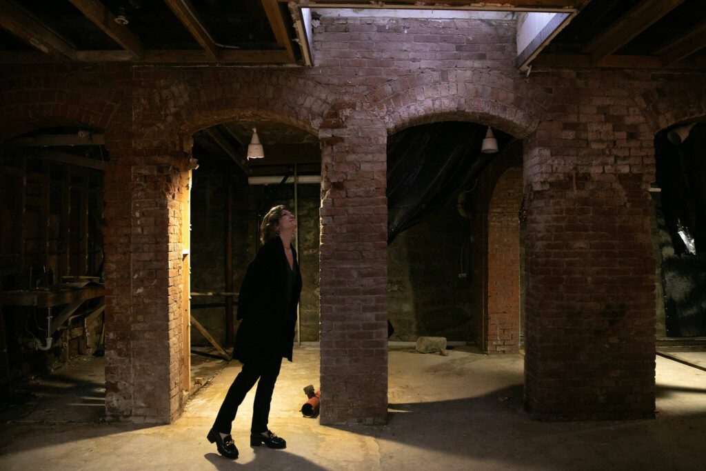 Maygen Hetherington, executive director of the Historic Downtown Snohomish Association, explores the basement level of the Marks Building on Thursday, Feb. 15, 2024, in downtown Snohomish, Washington. The building served as city hall from 1888 to 1928 and now houses HDSA and a number of other businesses. (Ryan Berry / The Herald)
