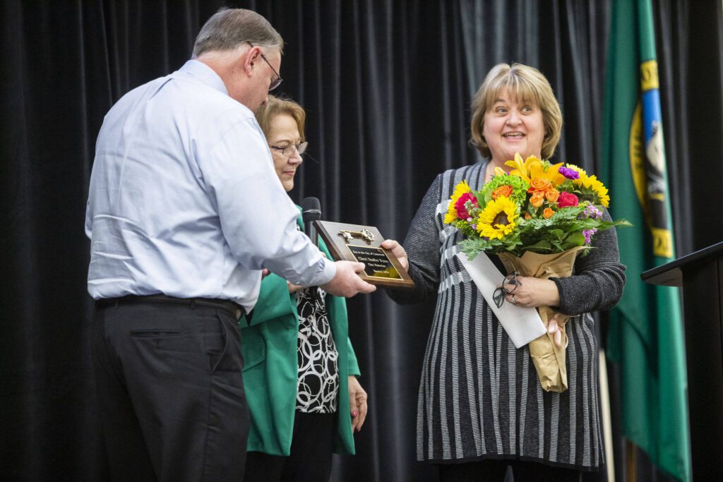 Lynnwood historian Cheri Ryan, right, receives a key to the city of Lynnwood on Wednesday, March 6, 2024 in Lynnwood, Washington. (Olivia Vanni / The Herald)
