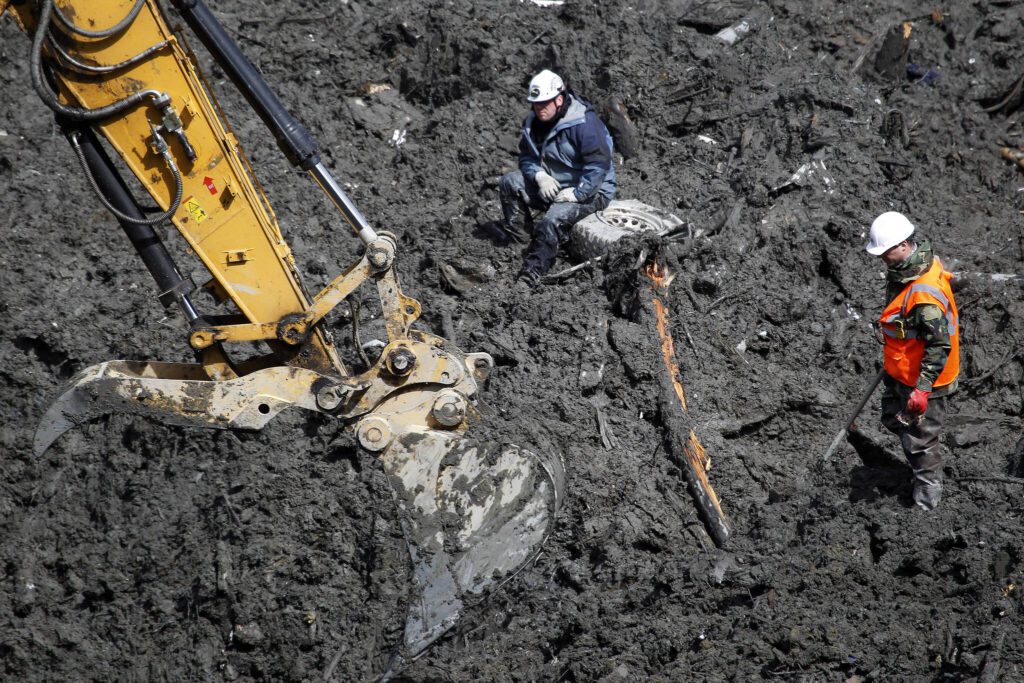 Workers and machinery search through debris for the two remaining missing persons in Oso on April 23, 2014. (Genna Martin / The Herald)
