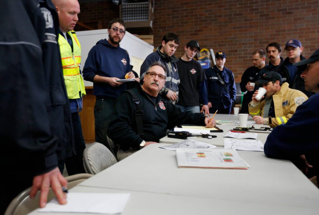 First responders gather inside the Oso Fire Department after a fatal mudslide washed over Highway 530 and the surrounding area just east of Oso, Saturday morning, March 22, 2014. (Annie Mulligan / For The Herald)
