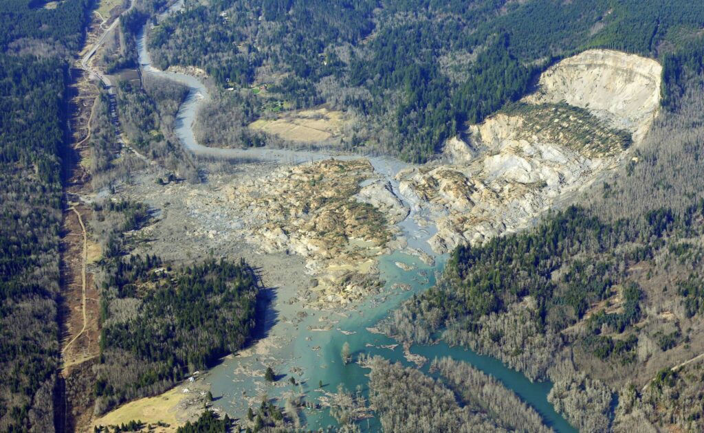 The massive mudslide that killed at least eight people and left dozens missing is shown in this aerial photo, Monday, March 24, 2014, near Arlington, Wash. The search for survivors grew Monday, raising fears that the death toll could climb far beyond the eight confirmed fatalities. (AP Photo / Ted S. Warren)
