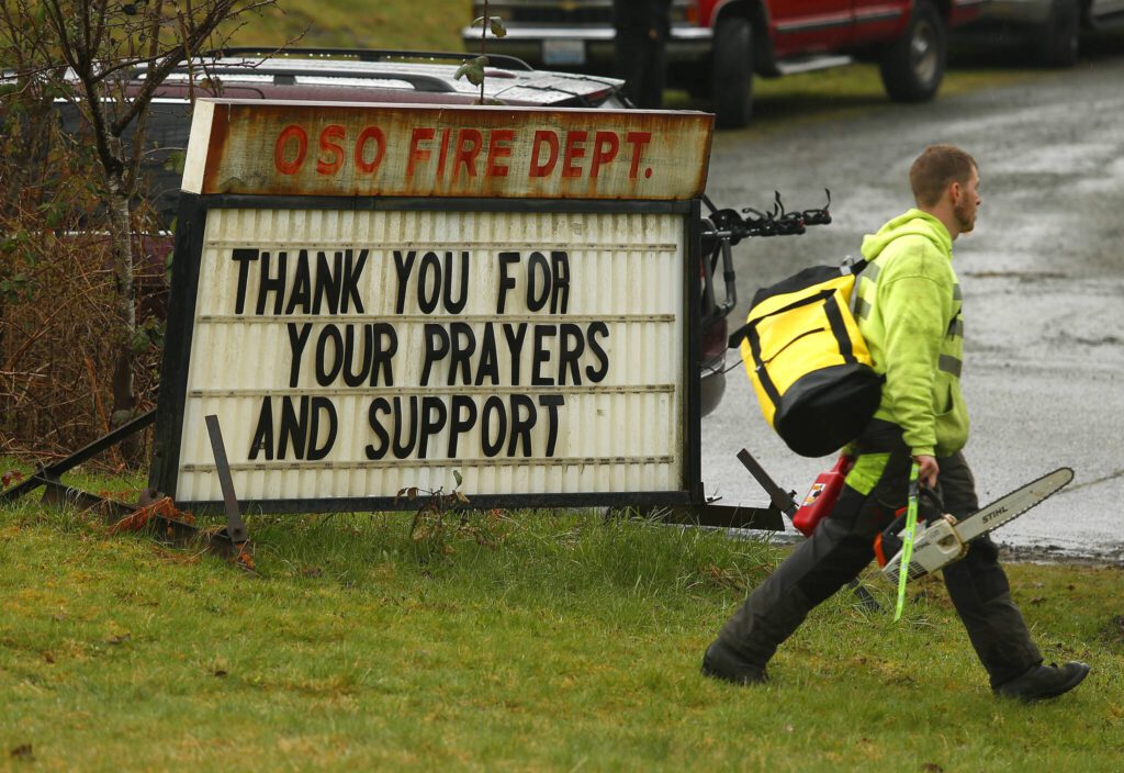 Volunteers arrive at the Oso Fire Department Tuesday March 24, 2014. (Mark Mulligan / The Herald)
