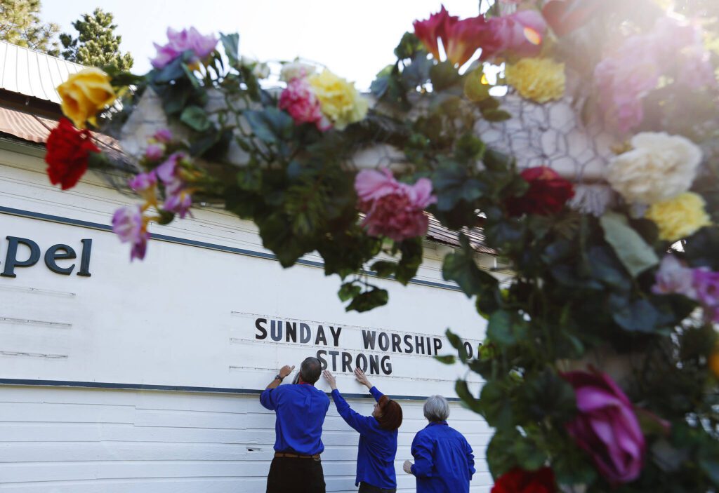 (LtoR) Chaplains Ray Thompson, Karen Solberg and Barbara Gilreath adjust the reader board at the Oso Community Chapel in Oso, Wash., on Tuesday, April 1, 2014. (Mark Mulligan / The Herald)
