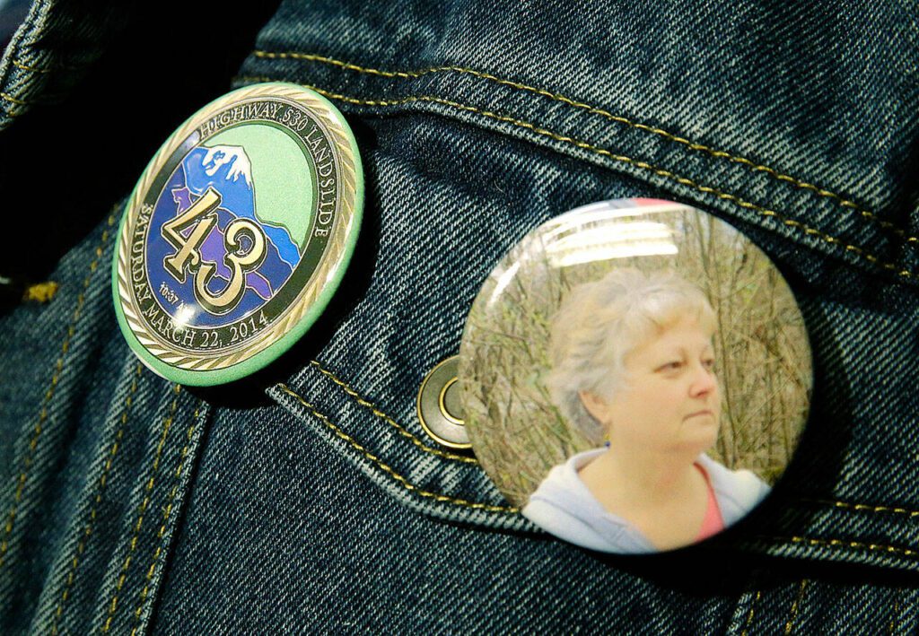 Tim Ward, who lost his wife Brandy in a 2014 landslide in Oso, Wash., wears buttons with Brandy’s photo and another commemorating all of the 43 deaths from the slide as he attends a session of King County Superior Court, Monday, Oct. 10, 2016, in Seattle. It was announced Monday that a settlement had been reached in a lawsuit brought by survivors and family members of people killed in the slide against the state of Washington and a timber company that logged an area above the site of the slide. (AP Photo/Ted S. Warren)
