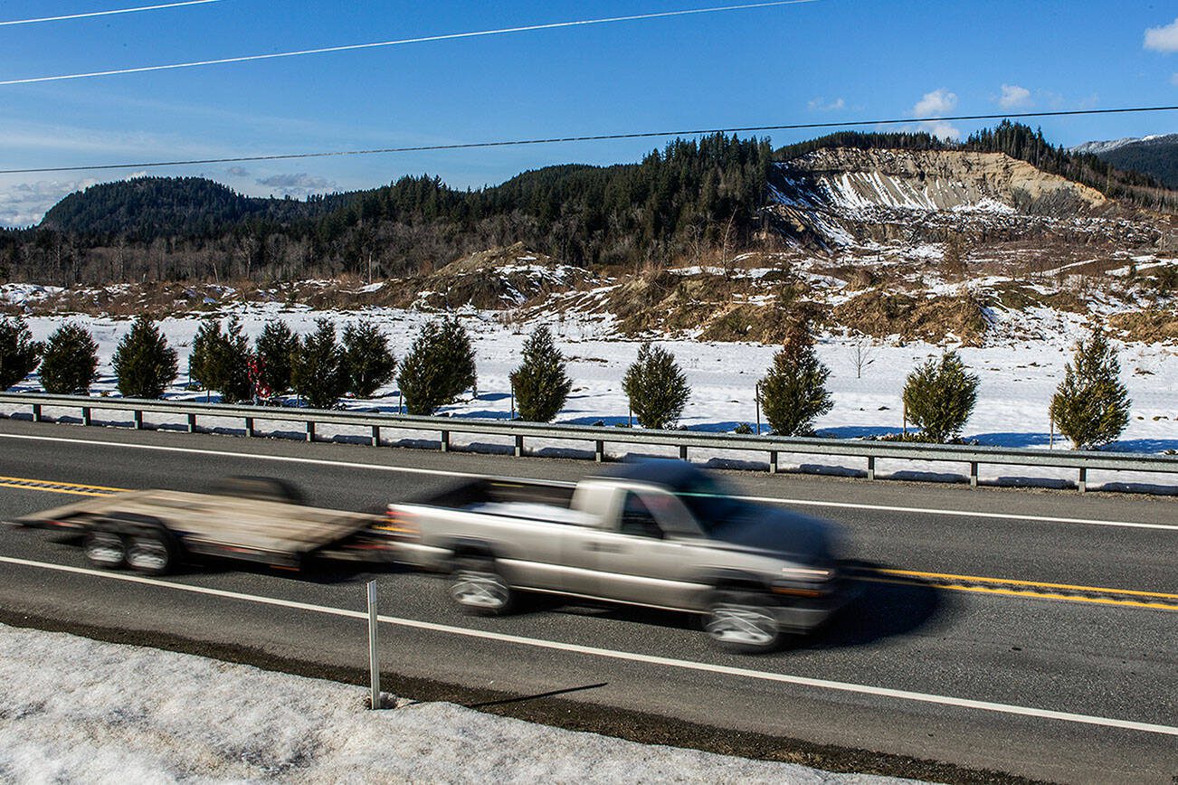 A car pulling an empty trailer drives eastbound along Highway 530 in front of the Oso mudslide site on Thursday, Feb. 21, 2019 in Oso, Wash. (Olivia Vanni / The Herald)