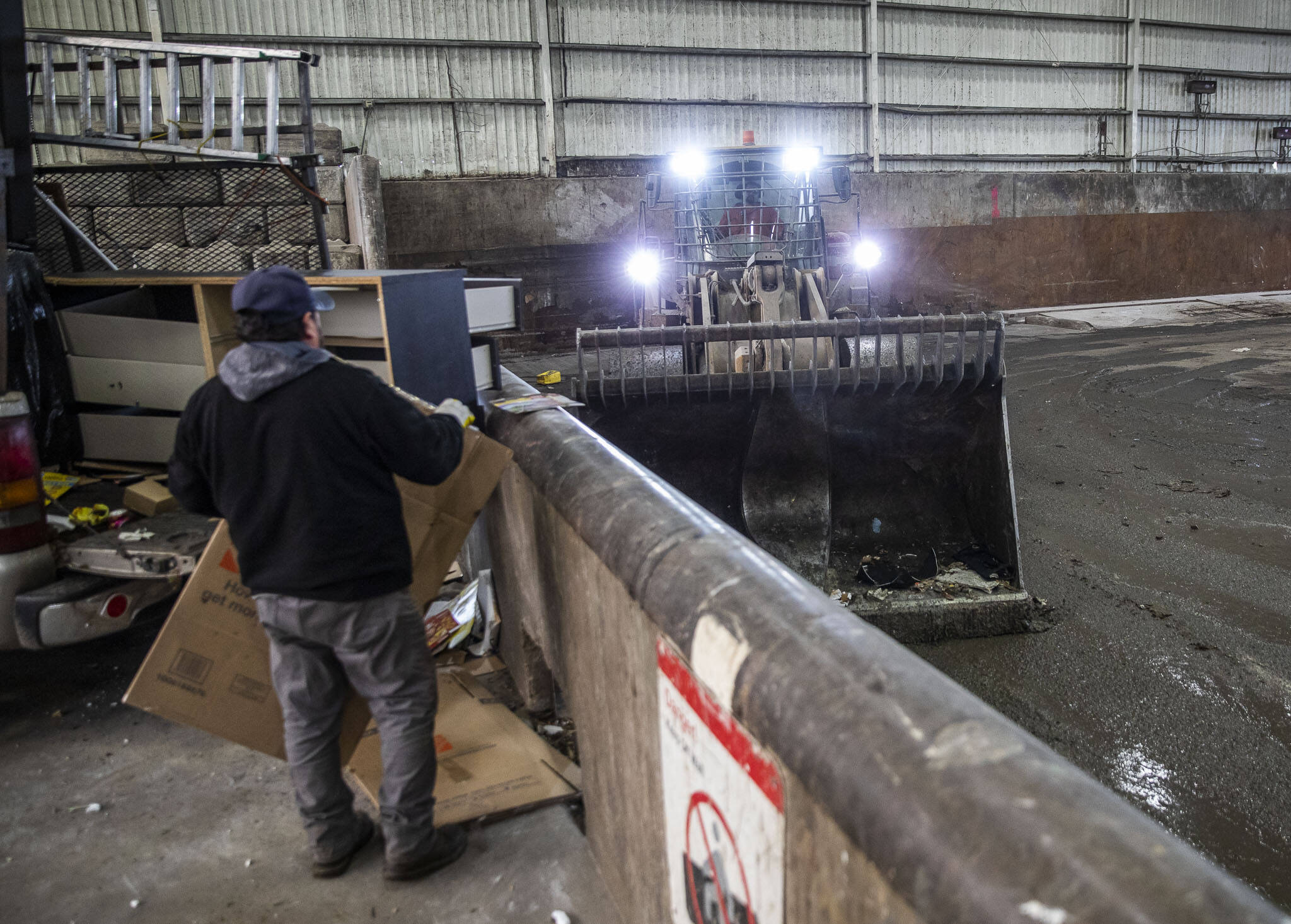 A front loader clears trash away from the wall as people unload their waste at Airport Road Recycling & Transfer Station at on Thursday, Nov. 30, 2023 in Everett, Washington. (Olivia Vanni / The Herald)